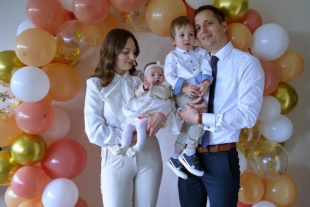 Junge Familie feiert die Taufe ihres kleinen Mädchens